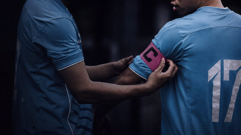Spieler in hellblauem Trikot mit der Nummer 17 hält ein Smartphone