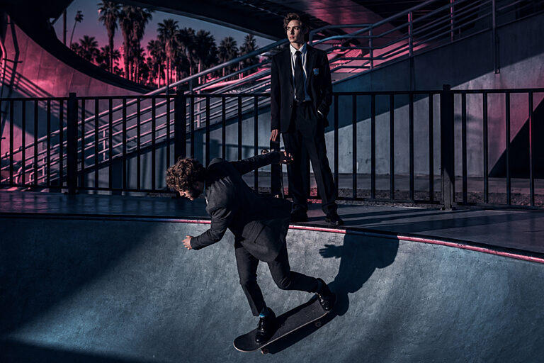 Skateboarder in einer Halle im magentafarbenen Licht